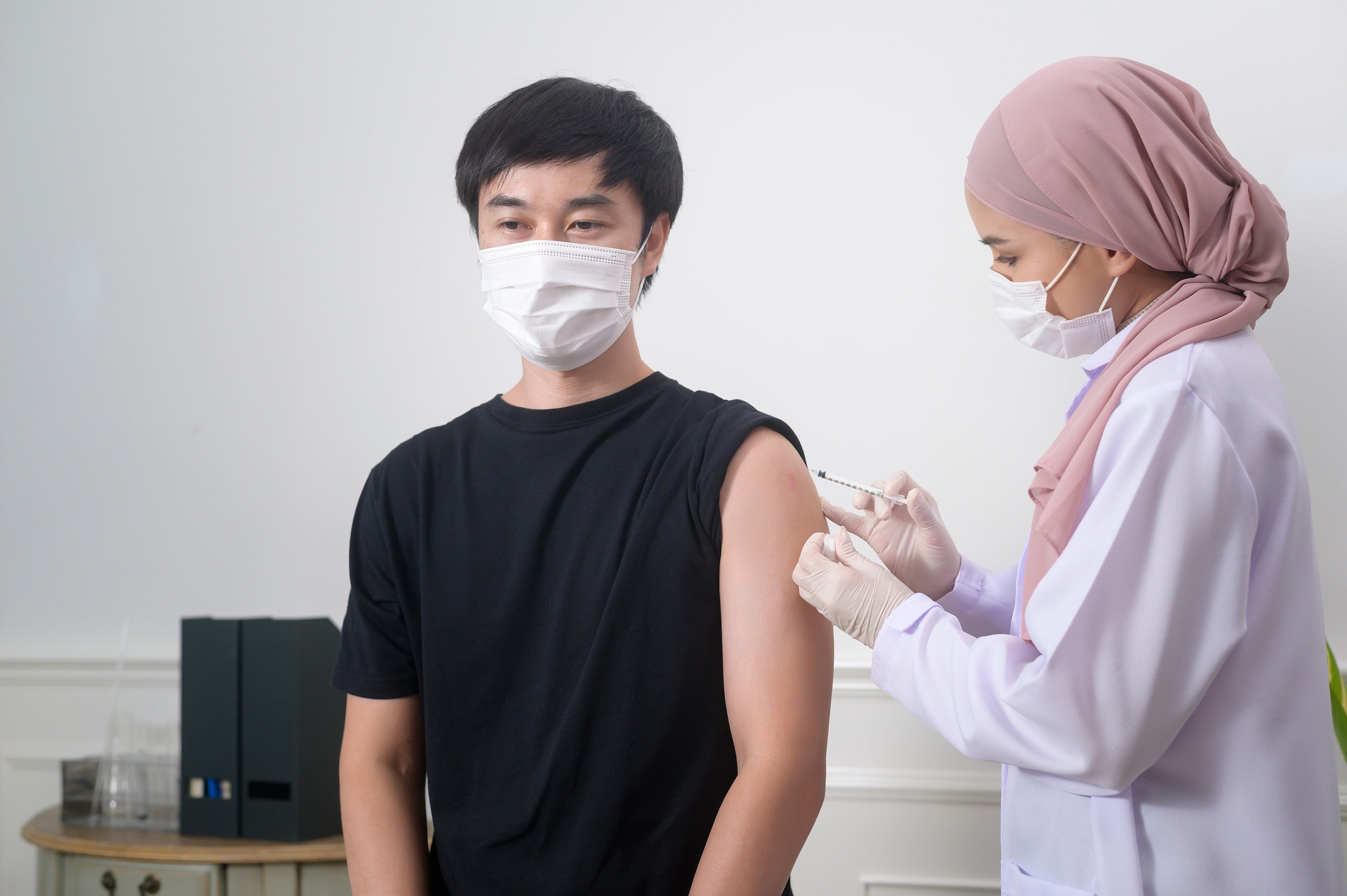 female-muslim-doctor-injecting-covid-19-vaccine-patient-arm-covid-19-vaccination-health-care-concept