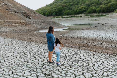 woman-girl-stand-hand-hand-dry-cracked-ground-look-lake-which-is-drying-up