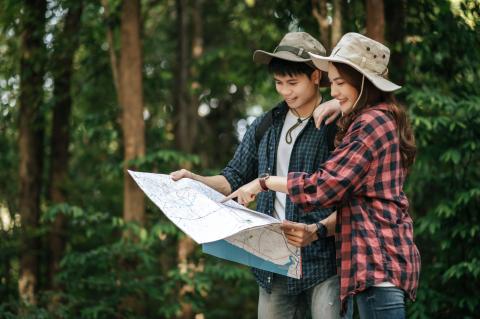portrait-young-asian-handsome-man-with-backpack-trekking-hat-pretty-girlfriend-standing-checking-direction-paper-map-while-walking-forest-trail-backpack-travel-concept